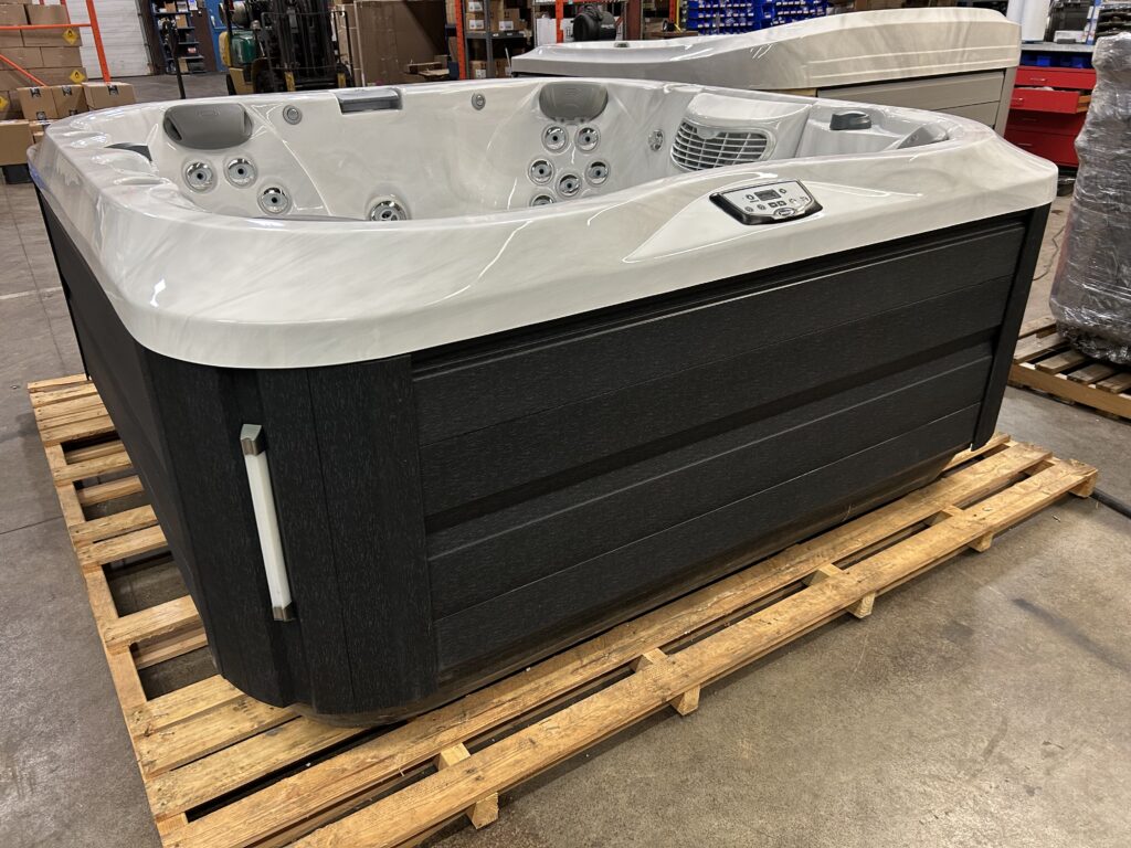 Jacuzzi J-335 hot tub exterior front view in warehouse – black cabinet – UJ100896491