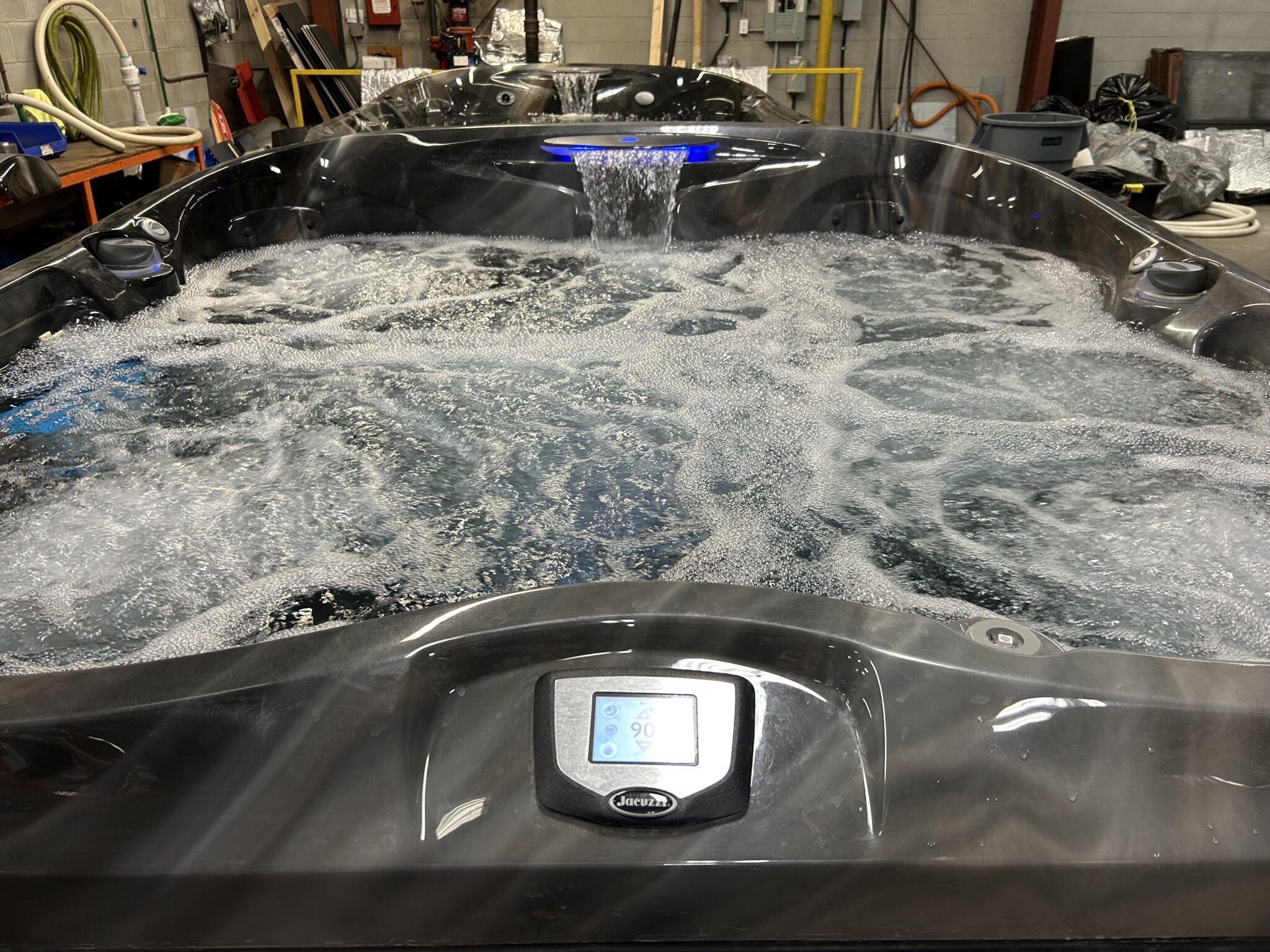 Jacuzzi J-475 hot tub with jets running and illuminated waterfall feature activated